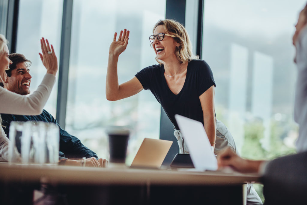 Une femme souriante concluant un accord avec d'autres personnes. Susciter les vocations de délégués syndicaux: un levier pour un dialogue social constructif.