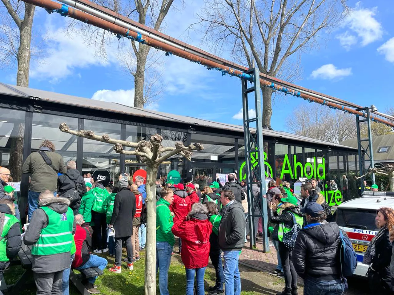 Un rassemblement de personnes avec des gilets verts et rouges lors d'une manifestation syndicale