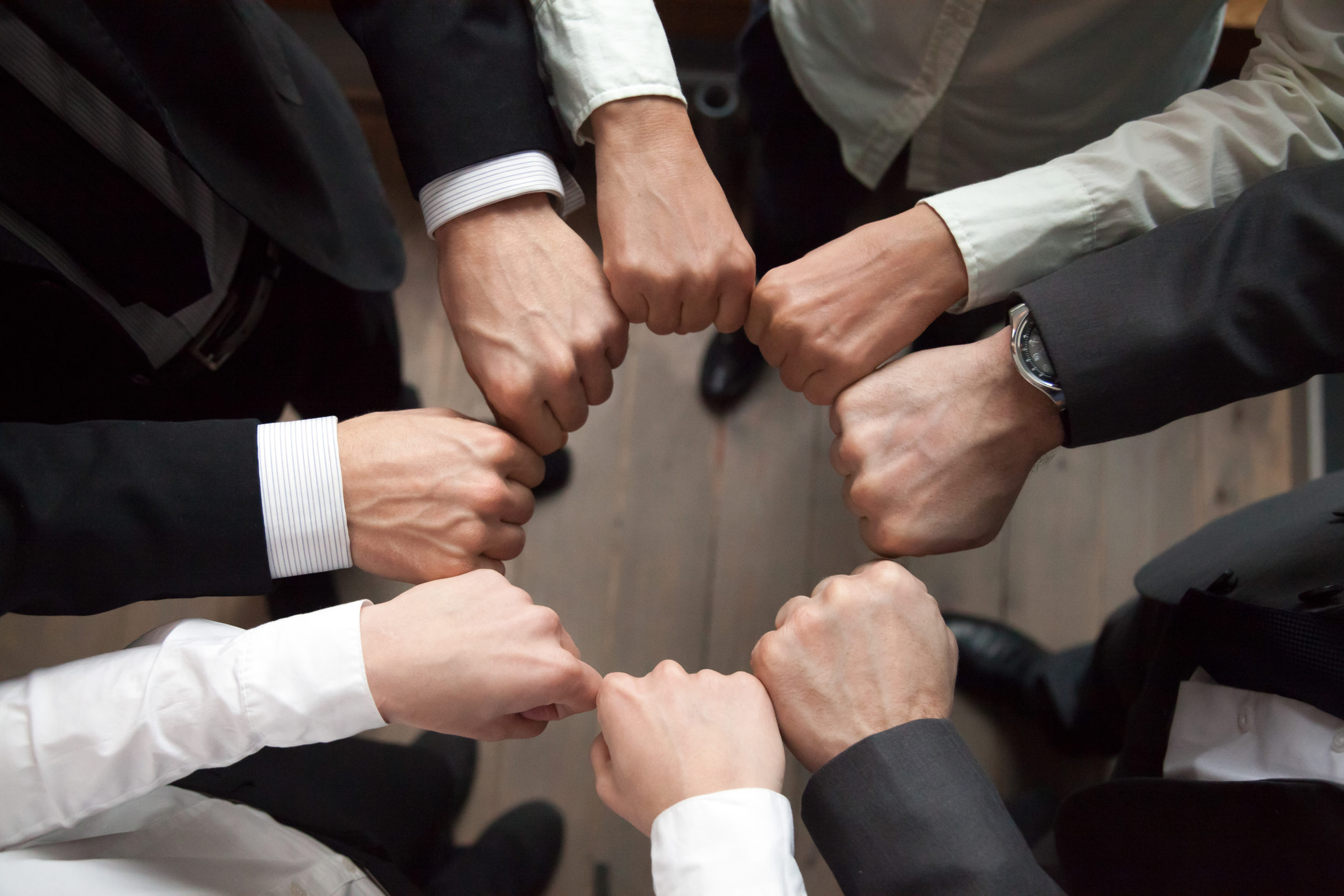 Un groupe d'individus forme un cercle avec leurs poings