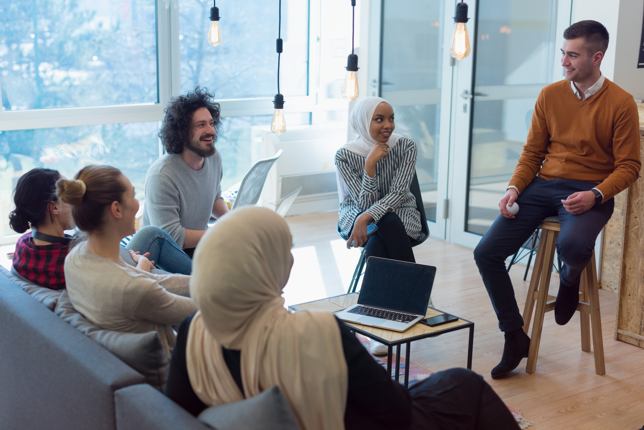 Un groupe de personnes souriantes discute dans un espace moderne