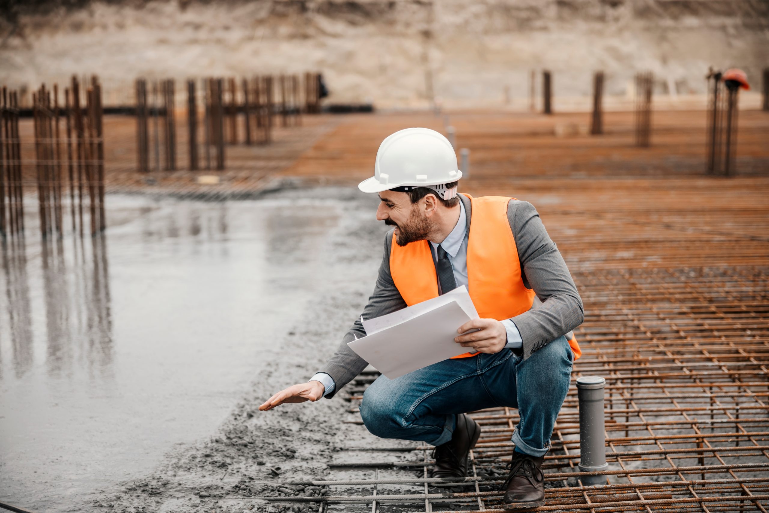 Un ingénieur inspecte un chantier avec des plans à la main